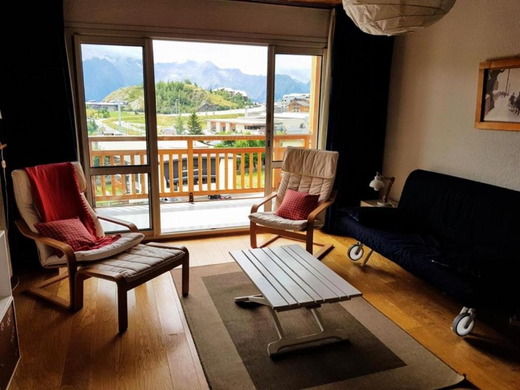 un salon avec un canapé et des chaises et une grande fenêtre dans l'établissement Résidence Choucas - APPARTEMENT ALPE D'HUEZ AVENUE DU RIFNEL MAE-3691, à Huez