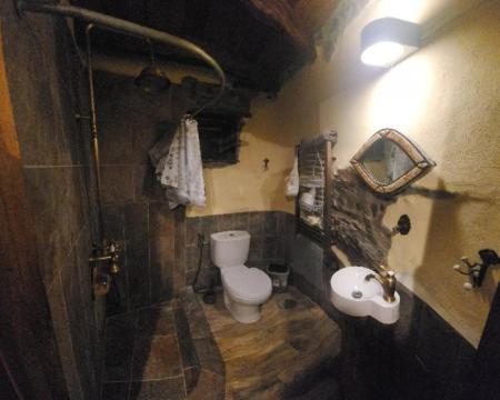 um banheiro com vaso sanitário e pia em Casa da Pedra em Talasnal