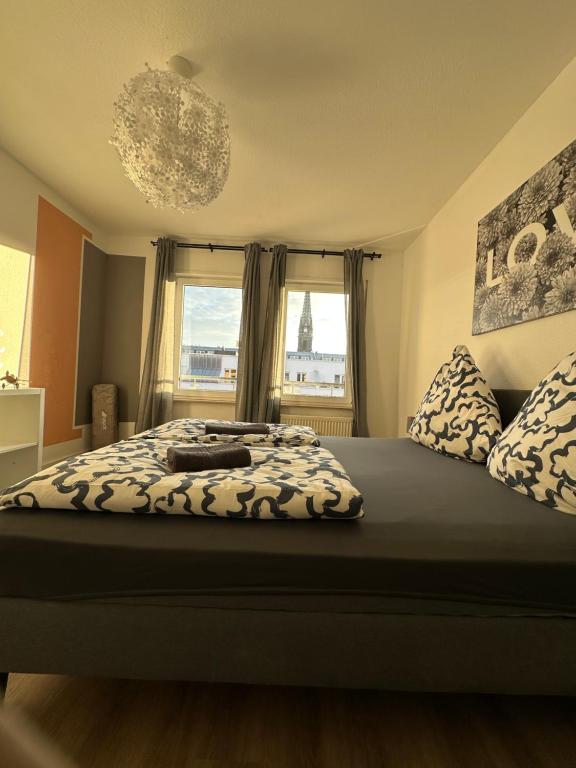 Un dormitorio con una cama grande con una ventana grande. en Zentrum - Blick über die Dächer von Leipzig, en Leipzig