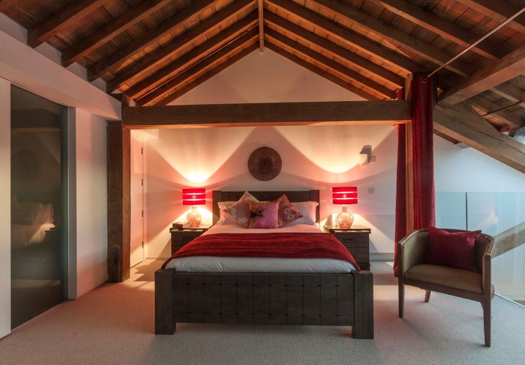 ein Schlafzimmer mit einem Bett, zwei Lampen und einem Stuhl in der Unterkunft Royal William Yard Apartments - Large and Luxurious with Free Parking in Plymouth