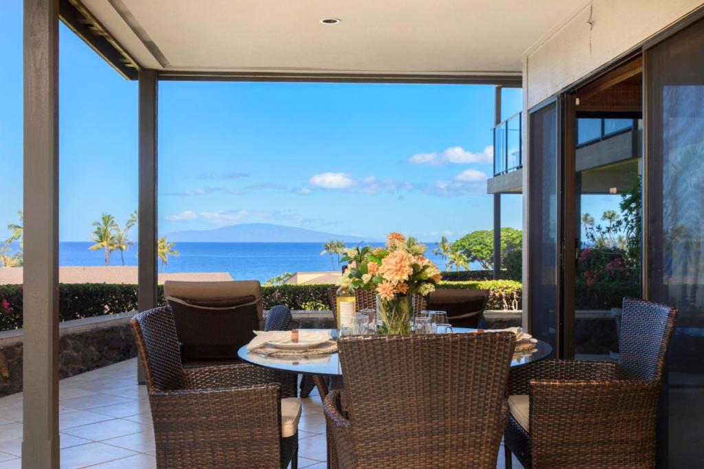 a dining room with a table and chairs and the ocean at KBM Resorts FREE CAR Wailea Elua WEV-2009 Maui Beach Condo with Luxury Amenities in Wailea