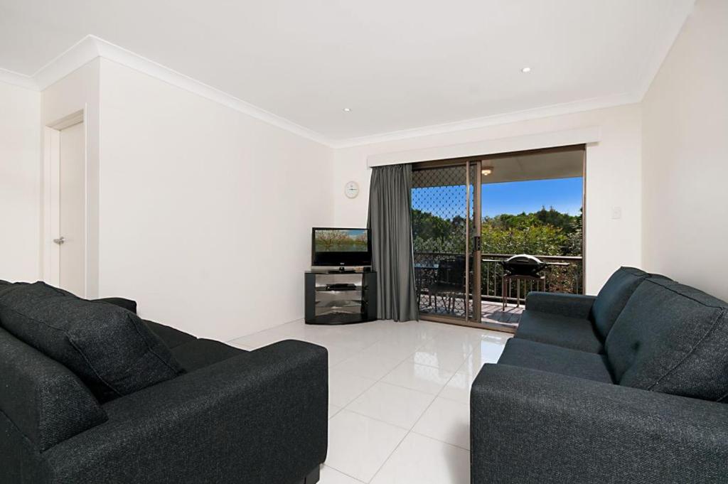 a living room with two couches and a television at Pacific Palms 4 Unit 4, 9-11 Terrace St Evans Head in Evans Head