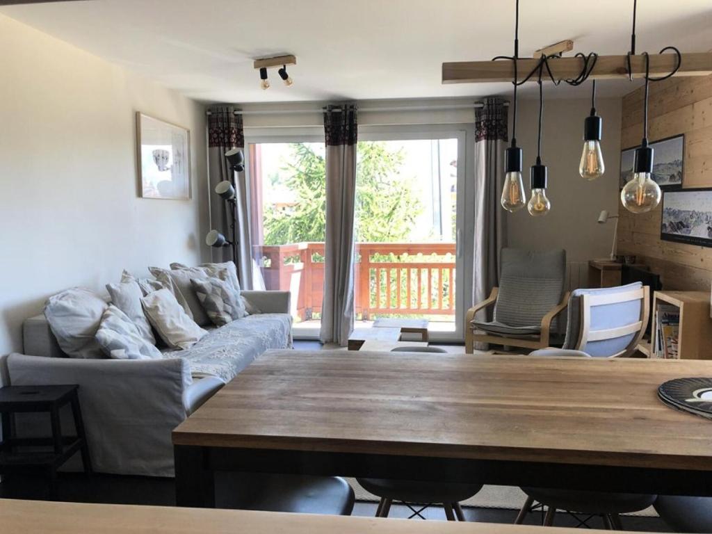 un salon avec un canapé et une table dans l'établissement Résidence Sarenne - APPARTEMENT 3 Pièces ALPE DHUEZ CENTRE STATION MAE-3031, à Huez