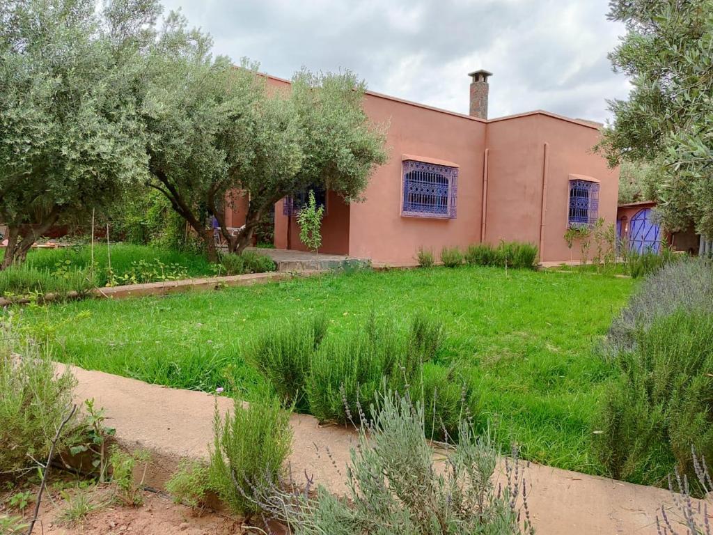 a house with a yard with grass and trees at Tissi House in Tahannout