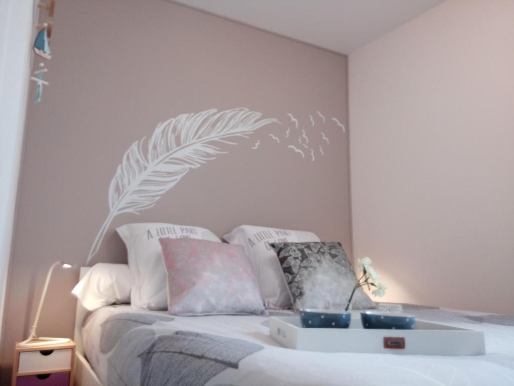 - une chambre dotée d'un lit blanc avec 2 bols bleus dans l'établissement Gîte LE BIVOUAC, à Fécamp