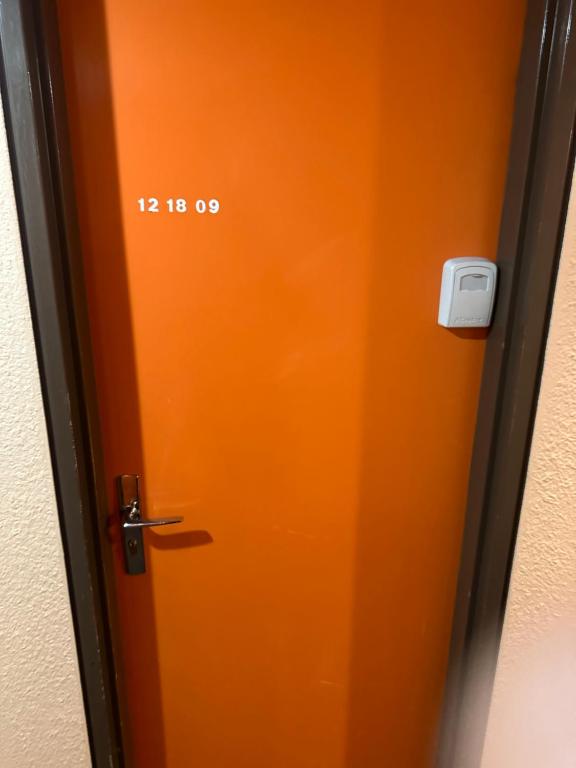 een oranje deur met het nummer erop bij La montagne in Villarembert