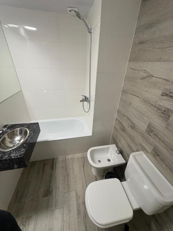 Un baño blanco con inodoro y lavabo. en Mendoza, en Rosario