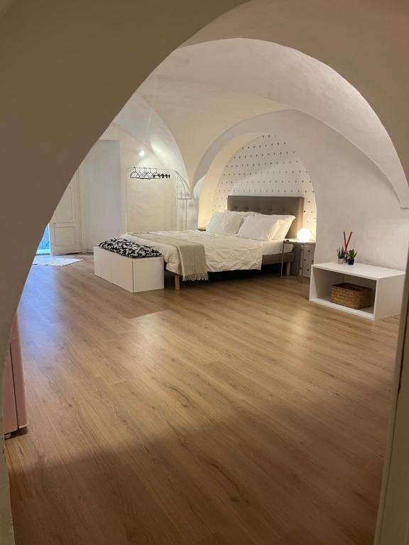 Un dormitorio con una cama grande en una habitación blanca. en VagaLuna Short Stay, en Catania