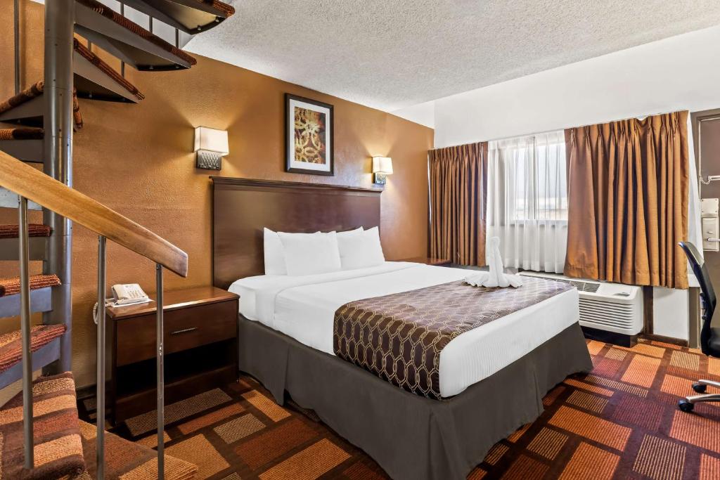 a hotel room with a bed and a staircase at Best Western Tower West Lodge in Gillette