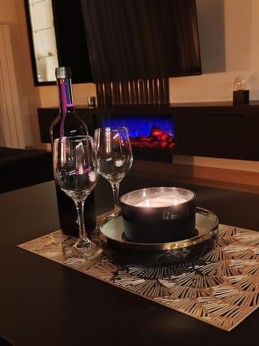 a table with two wine glasses and a bottle of wine at Apartman D346 u sklopu Aparthotel Vučko in Jahorina