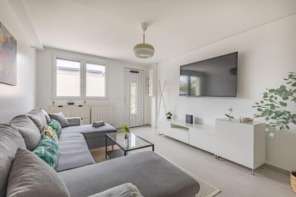 un salon avec un canapé et une télévision dans l'établissement Maison paisible T3 à 20min de Paris, à Vitry-sur-Seine