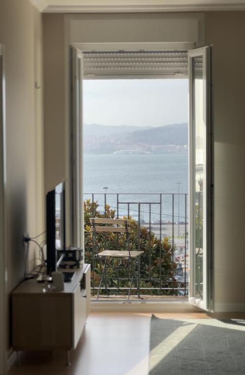 a living room with a large window with a view of the ocean at Apartamento Miracies in Vigo