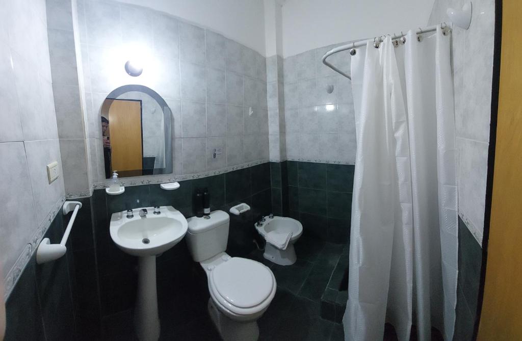 ein Badezimmer mit weißer Toilette und Waschbecken in der Unterkunft Departamentos Falucho 3 in Santa Rosa