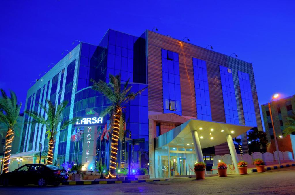 a building in a city at night at Larsa Hotel in Amman