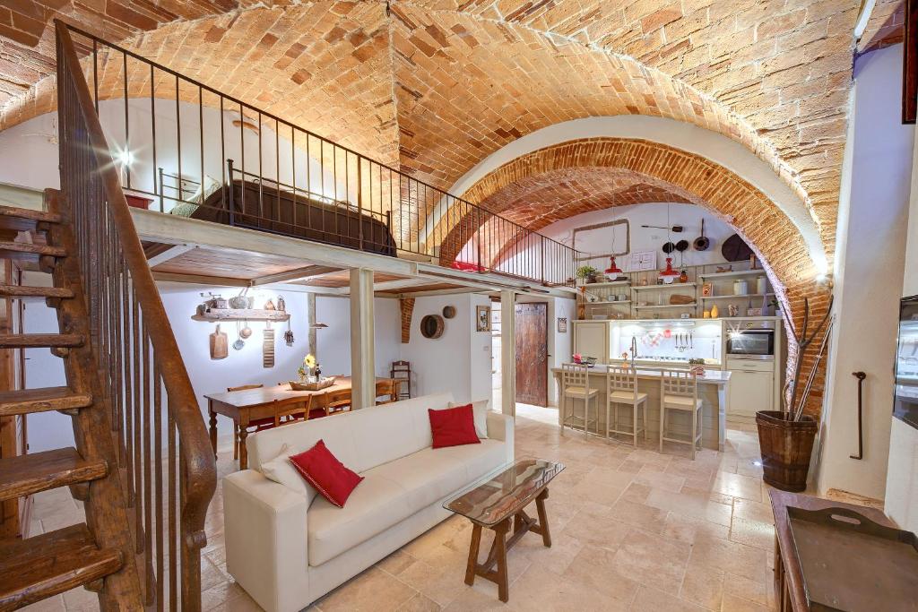 a living room with a white couch and a brick wall at La Volta su Arezzo in Arezzo