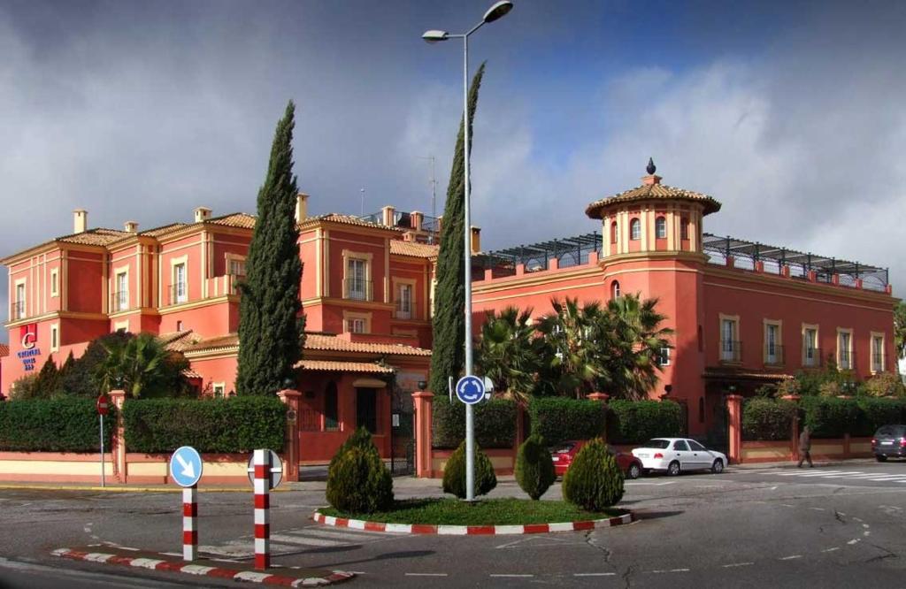 a large red building with a car parked in front of it at Hotel Cristina in Fregenal de la Sierra