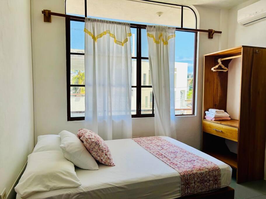 Un dormitorio con una cama con una ventana grande. en Suite con acceso a terraza vista a la Bahia, en Puerto Ayora