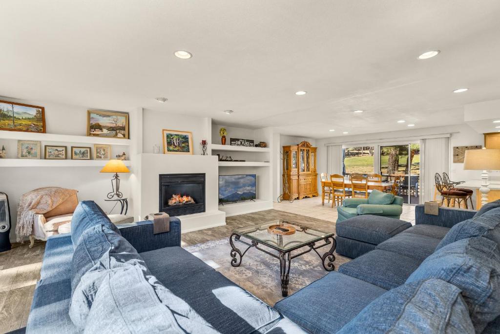 ein Wohnzimmer mit blauen Sofas und einem Kamin in der Unterkunft Charming 3BD Continental Country Club Retreat in Flagstaff in Flagstaff