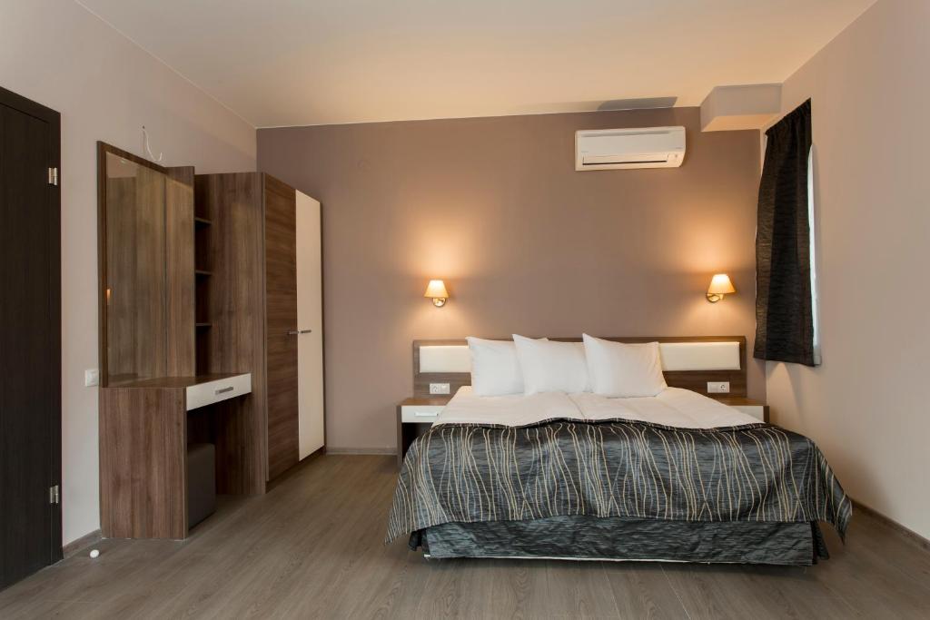 a bedroom with a bed with white sheets and pillows at Hotel Provadia in Provadiya