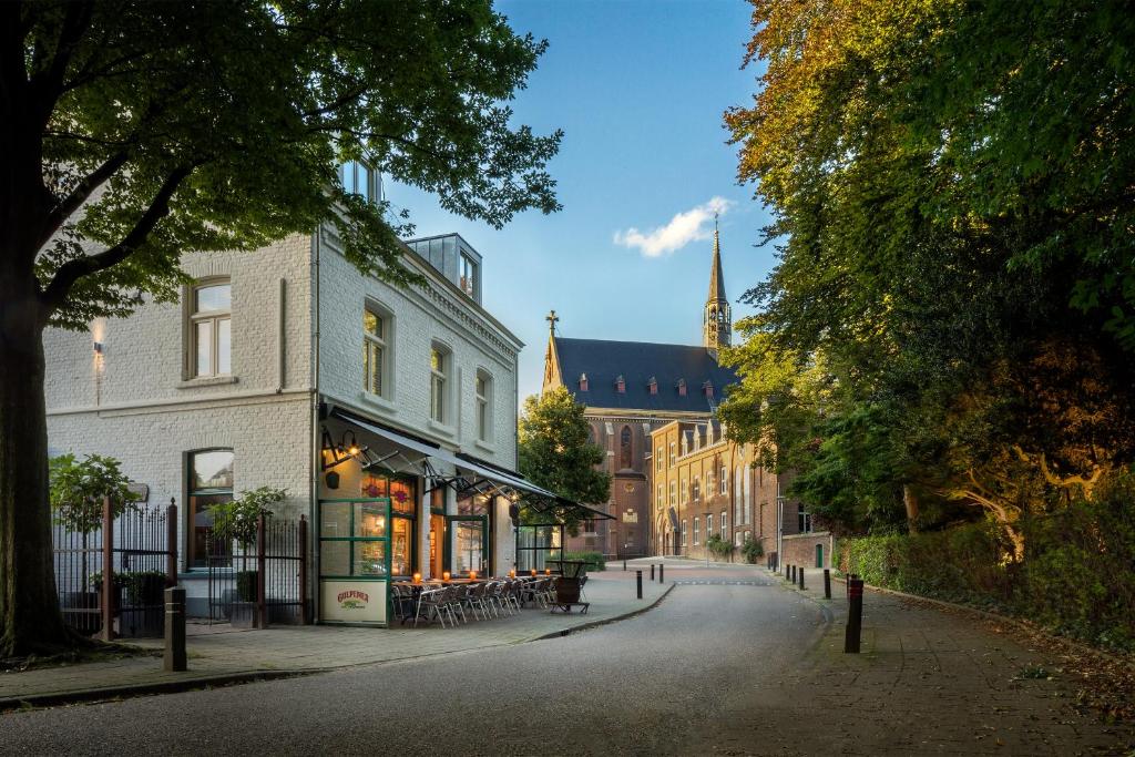 een straat in een stad met een gebouw en een kerk bij Hotel Restaurant Café Parkzicht in Roermond