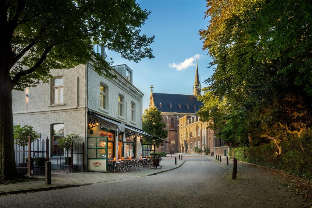 a street in a town with a building and a church at Hotel Restaurant Café Parkzicht in Roermond