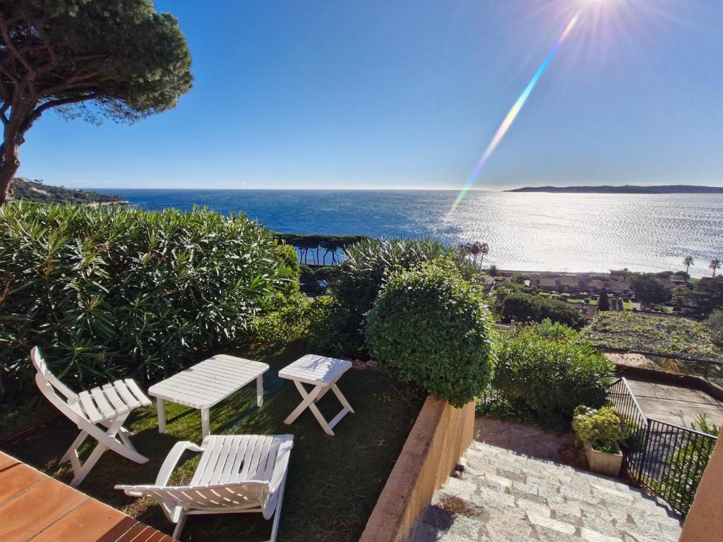 d'une terrasse avec 2 chaises, une table et un arc-en-ciel. dans l'établissement Appartement 2 pièces avec piscine et garage à Sainte-Maxime - FR-1-780-71, à Sainte-Maxime