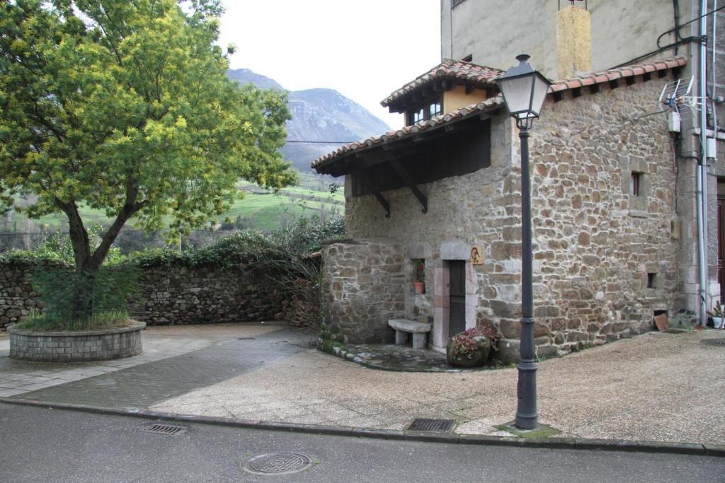 un edificio de piedra con una luz de la calle delante de él en Ca María Santa, en Proaza