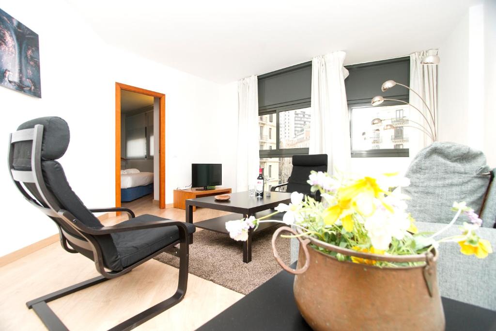 un soggiorno con sedia e vaso di fiori di Apartment Bright Sagrada Familia a Barcellona