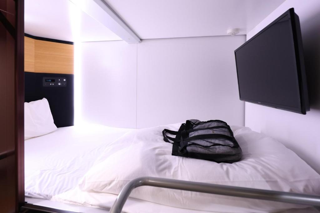 Postel nebo postele na pokoji v ubytování global cabin Yokohama Chukagai