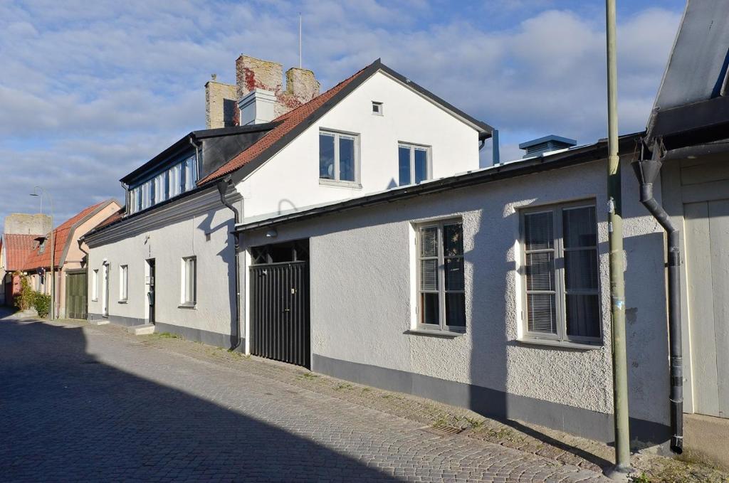 un edificio blanco al lado de una calle en Visby Innerstad Lägenheter & Rum en Visby