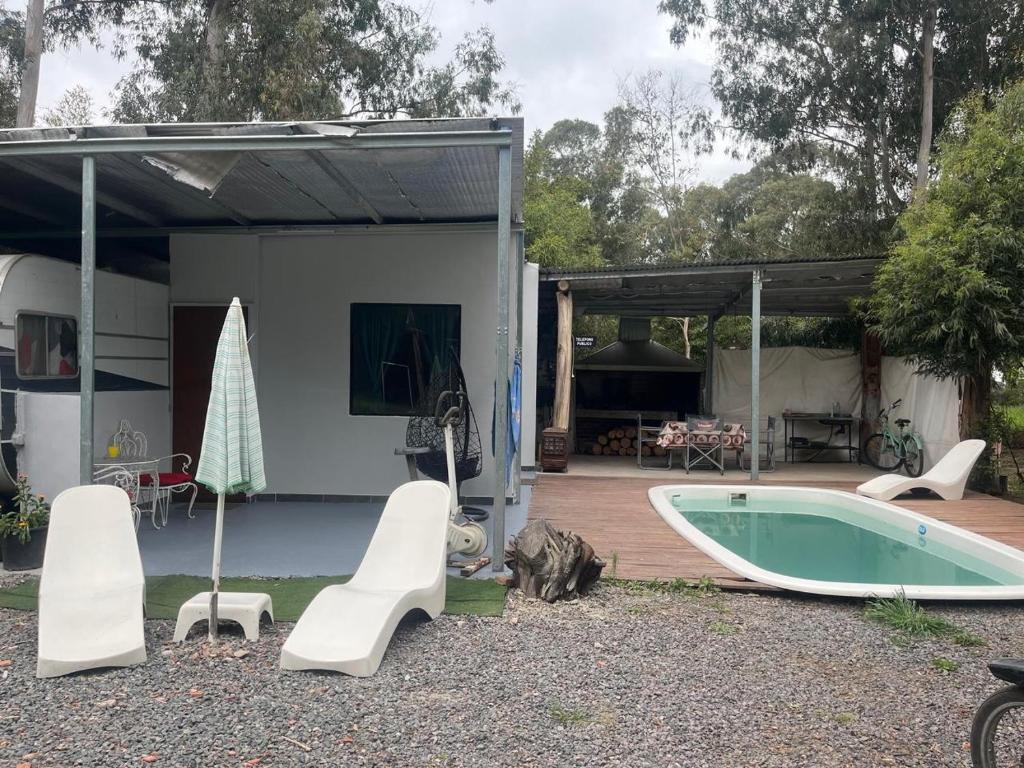 un cortile con piscina e una casa di Bungalow Sobre Ruedas Viento Potro a San Miguel del Monte