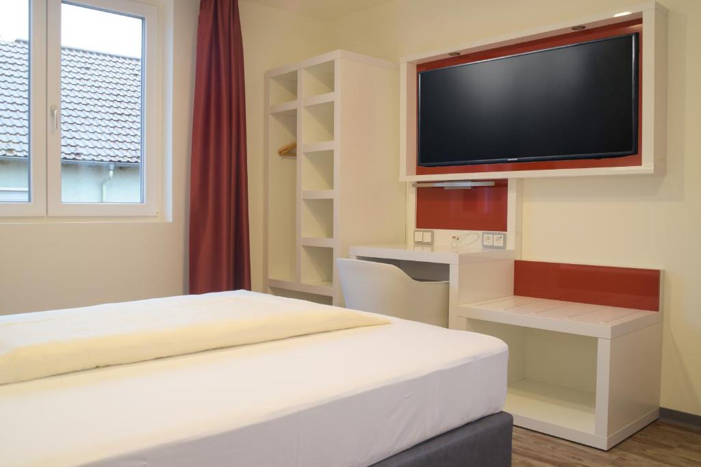 a bedroom with a bed and a flat screen tv at Hotel Arts in Sankt Leon-Rot