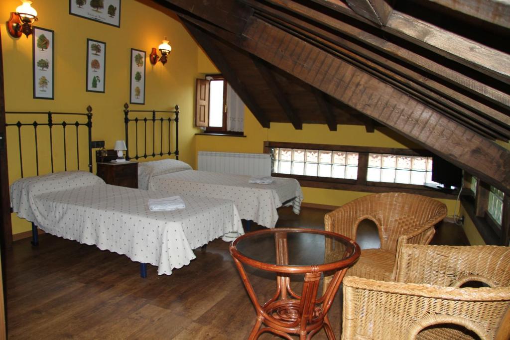 um quarto com duas mesas e cadeiras de vime em Ca María Fayas em Proaza