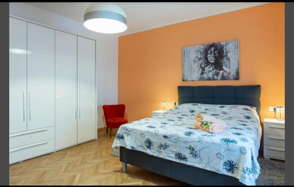 een slaapkamer met een bed en een rode stoel bij Apartment Punta with garage, balcony, garden and sea view in Opatija