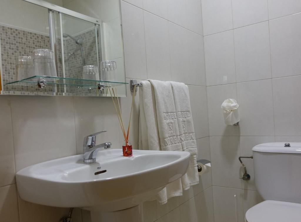 a white bathroom with a sink and a toilet at Hotel Andrea´s in Los Cristianos