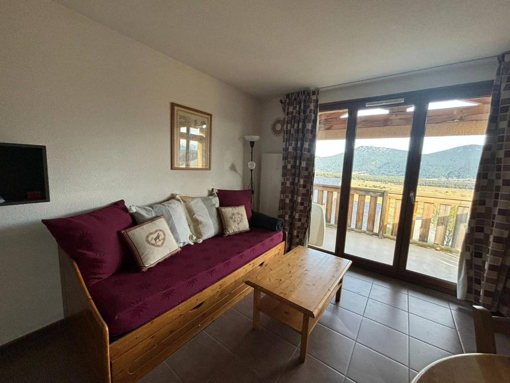 un salon avec un canapé violet et une table dans l'établissement Appartement 2 pièces calme avec parking aux Angles - FR-1-593-119, aux Angles