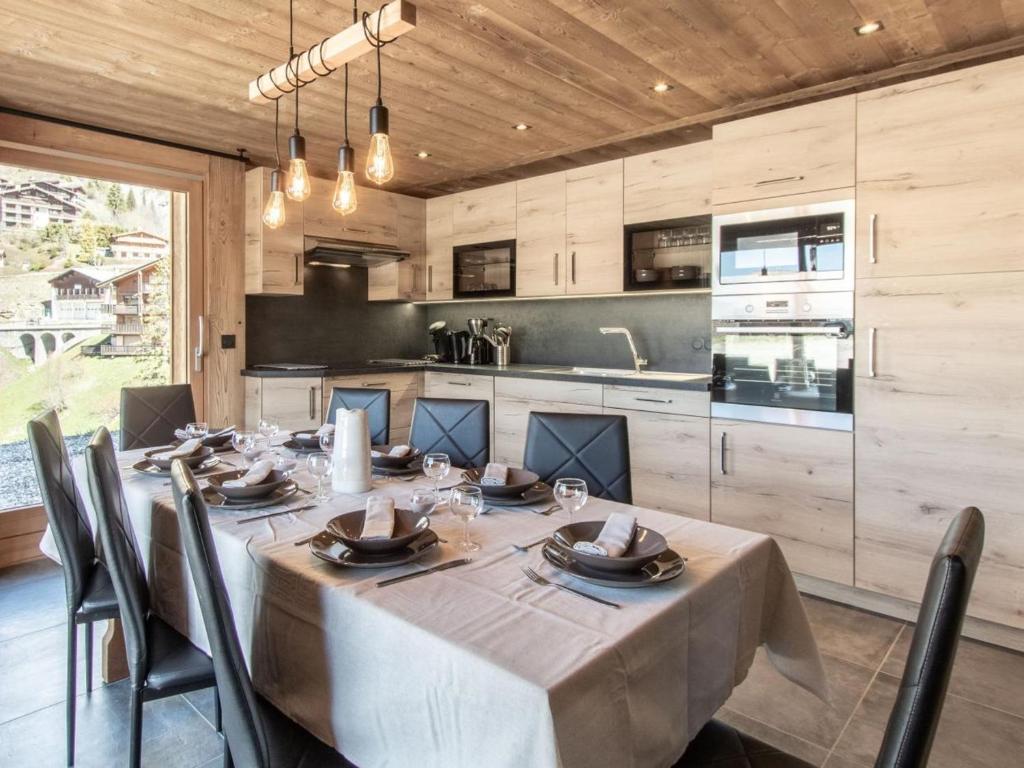 une salle à manger avec une table et une cuisine dans l'établissement Appartement cosy avec sauna et spa, pied des pistes - FR-1-467-141, au Grand-Bornand