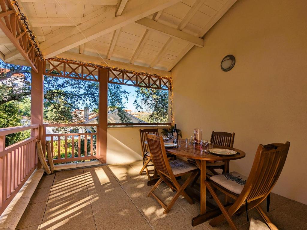 une salle à manger avec une table et des chaises sur un balcon dans l'établissement T3 76m² avec terrasse, balcon, à 100m de la plage d'Eyrac, parking et WIFI - FR-1-420-154, à Arcachon