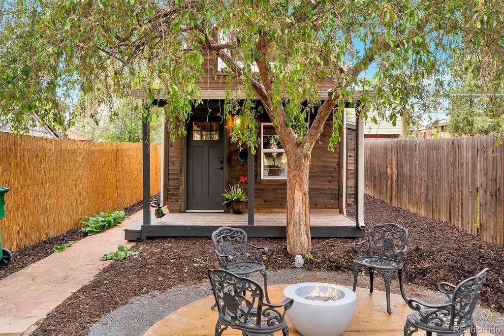 a patio with chairs and a tree in front of a house at Unique Denver Tiny House Skiing, Shopping, Hiking in Englewood