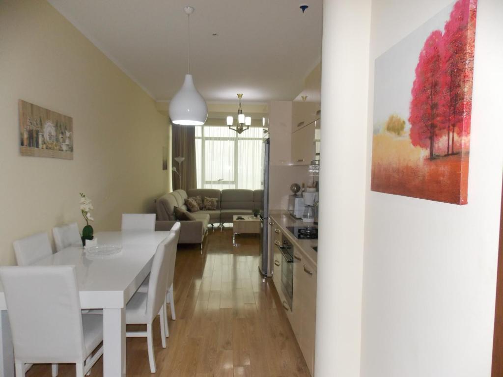 uma cozinha e sala de estar com uma mesa branca e cadeiras em Anna's Sea View Apartment em Batumi