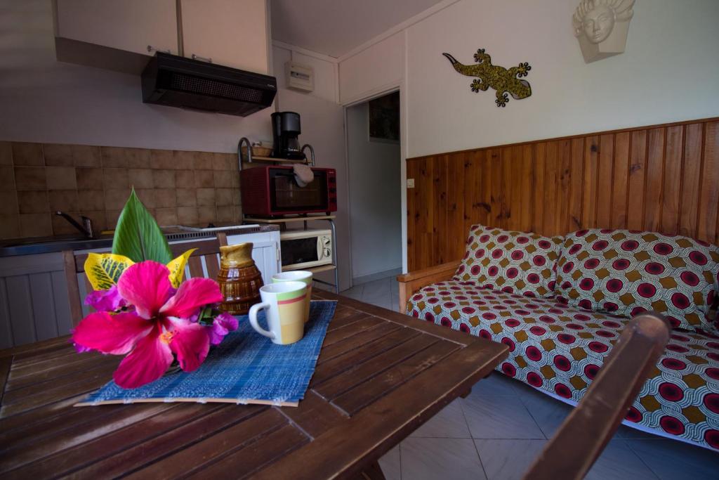 a table with a flower on it in a living room at Gîte L'adérobade in Le Gosier