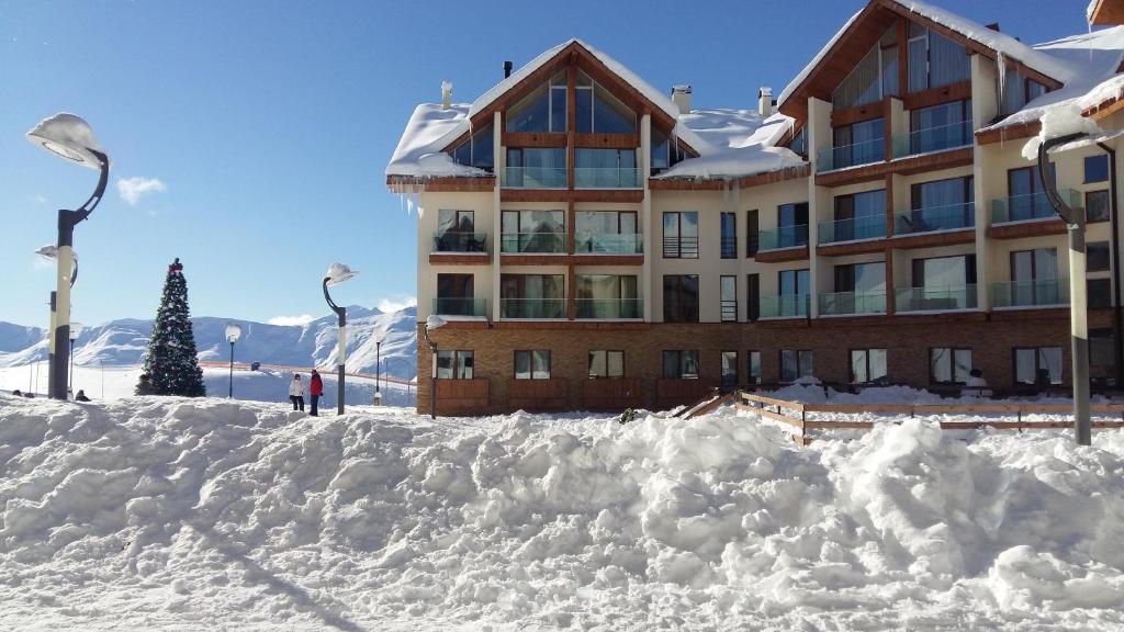 a snow covered building in front of a ski lodge at iSKI - New Gudauri Apartment 2 in Gudauri