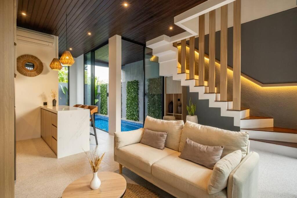 ein Wohnzimmer mit einer Couch und einer Treppe in der Unterkunft Private Villa Ayra 8C by OriVista 10mins to Melasti Beach in Uluwatu