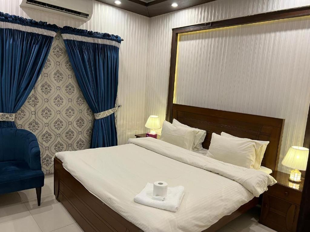 a bedroom with a bed with a white towel on it at Hotel Imperial ByHI in Karachi