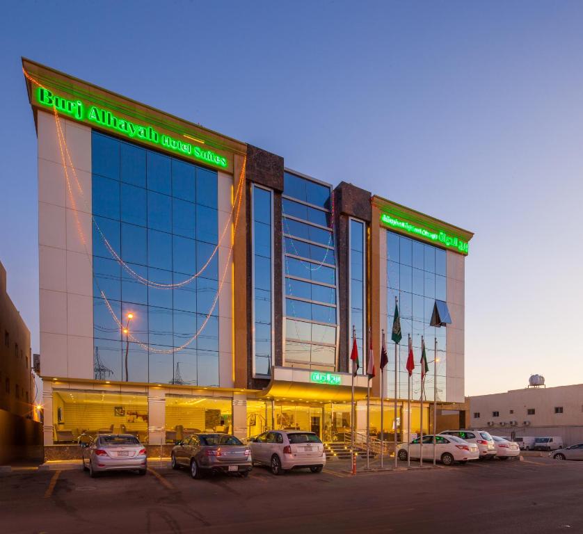 a large building with cars parked in a parking lot at Burj Alhayah Alfalah in Riyadh