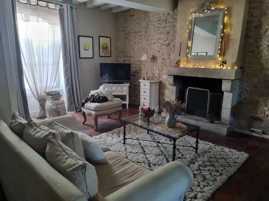 un salon avec un canapé et une cheminée dans l'établissement Charmante maison ancienne avec cour, à Aleçon