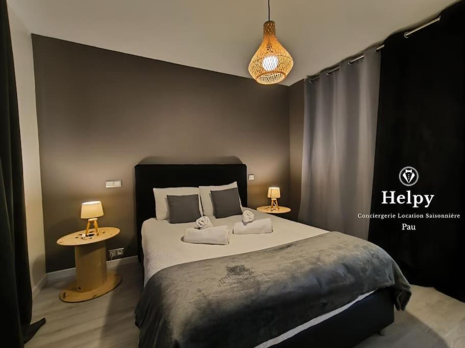 une chambre avec un lit avec deux tables et deux lampes dans l'établissement Bel appartement-Foire expo-4 pers-Parking gratuit, à Billère