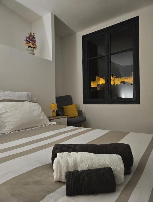 a bedroom with a large bed and a window at Vue Cité Médiévale Castel View in Carcassonne