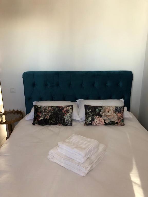 a bed with a blue headboard and pillows at La Vista Ultracentral - Private Parking in Craiova
