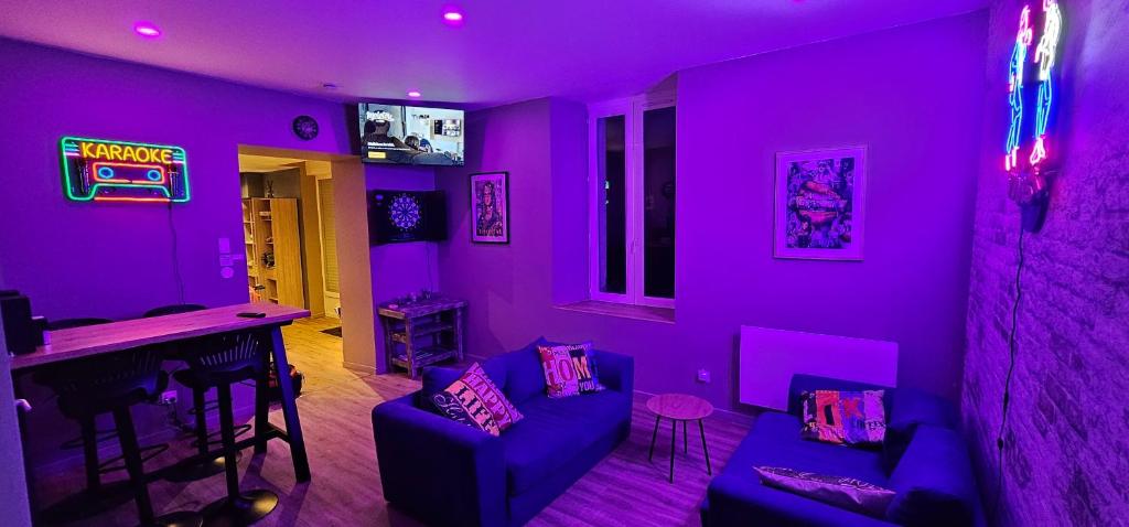 a purple room with a couch and a bar at Le Clos Maldier - Gîte de la Belle vue in Laon